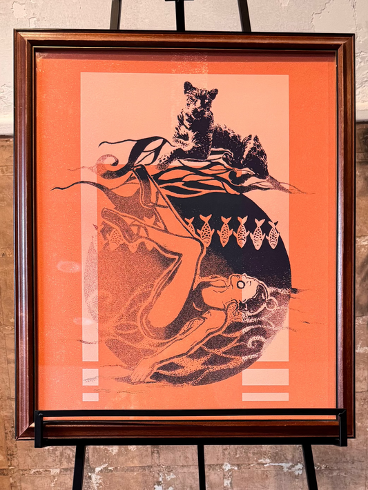 Framed artwork on an easel against a textured wall. Burnt marmalade hue featuring ballet dancer, fish and jaguar. Artwork by Joëlle Diane of Monochrome Canvas.