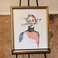 Framed artwork in a gold frame on an easel against a textured wall. Portrait of woman with fish swimming in front of her and her body disappears into the background. Artwork by Joëlle Diane of Monochrome Canvas. 