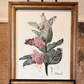 Framed artwork of monarch butterfly on milkweed plant on an easel against a textured wall. Artist: Joëlle Diane