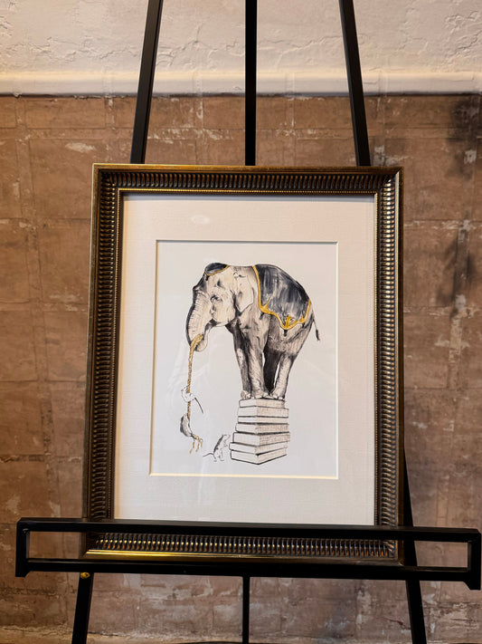 Framed artwork of an elephant standing atop books with mice climbing up a rope held in it's trunk. Gold frame against a textured wall. Artist: Joëlle Diane