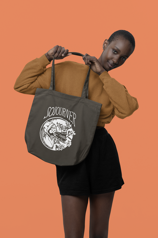 Woman holding Sojourner Truth tote bag - one color print in white featuring iconic phrase "The truth is powerful and will prevail"