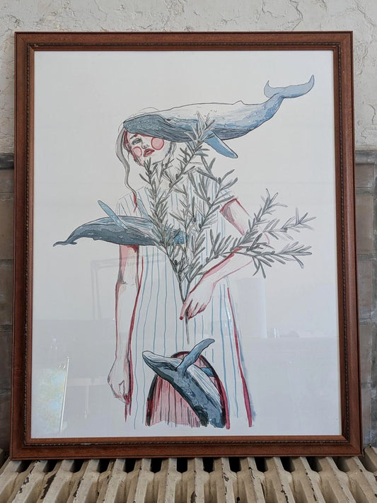 Framed artwork of a woman with whales swimming around her holding an olive branch against a white background.