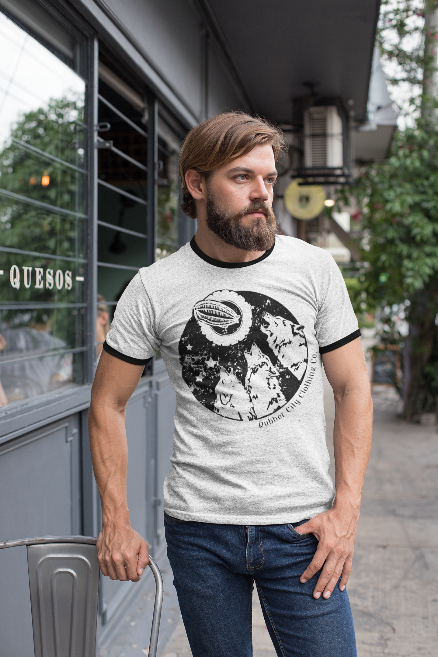 bearded man wearing ringer t-shirt featuring Rubber City Clothing logo and three wolves howling at the tire moon. Designed by Joëlle Diane of Monochrome Canvas.